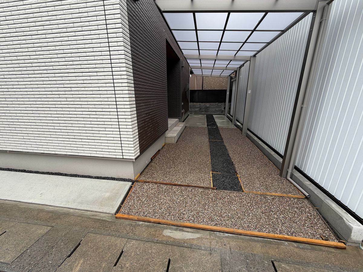 洗い出しで仕上げた通路。中央に黒い石の帯を通している
